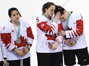 Canadian defenceman Lauriane Rougeau (5) comforts forward Rebecca Johnston (6) after losing to the United States in the gold medal final.