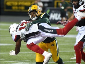 Andrew Lue, then with the Eskimos', tackles the Redblacks' Daje Johnson in a regular-season game last July. Lue signed with the Redblacks as a free agent on Thursday. Ed Kaiser/Postmedia