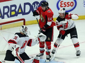 Senators' Alexandre Burrows and New Jersey Devils' Sami Vatanen  react as the puck comes off the goal post behind goaltender Keith Kinkaid during Tuesday night's game. (THE CANADIAN PRESS)