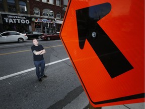 Files: Corey Hackett, co-owner of Top of the World on poses by some construction signs on Rideau St. Thursday August 27, 2015. The street is slated to close to car traffic for three year for LRT construction which Hackett fears will hurt business.