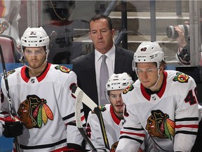 Assistant coach Kevin Dineen stands behind the Blackhawks bench during a November game in Florida. Four years ago, he coached the Canadian women's team to Olympic gold at Sochi.