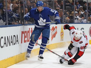 Senators forward Colin White tries to close off the Leafs' Nikita Zaitsev along the boards in the first period.