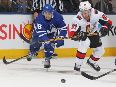 Mitchell Marner of the Maple Leafs battles Mark Stone of the Senators for the puck in the third period. Saturday's game was the first for Stone after he missed the previous nine because of a leg injury.