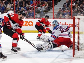 Senators defenceman Mark Borowiecki, middle, watches as centre Derick Brassard tips his pass into the Rangers' net for a goal during the second period of Saturday's game at Canadian Tire Centre.