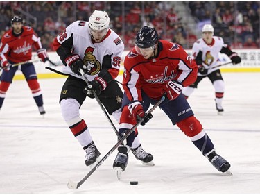 WASHINGTON, DC - FEBRUARY 27: John Carlson #74 of the Washington Capitals and Magnus Paajarvi #56 of the Ottawa Senators battle for the puck during the first period at Capital One Arena on February 27, 2018 in Washington, DC.