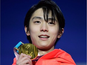 Gold medallist Yuzuru Hanyu of Japan poses on the podium after winning the men's singles figure skating title on Saturday.