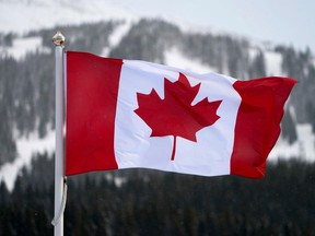 In this file photo taken on November 30, 2017 the Canadian flag flies over the Lake Louise ski lodge in the Canadian Rockies in Lake Louise, Alberta. Canadians will soon be singing a new tune after parliament passed a bill to change the lyrics of the national anthem to make it gender neutral.