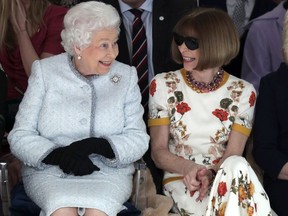 Britain's Queen Elizabeth sits next to fashion editor Anna Wintour as they view Richard Quinn's runway show before presenting him with the inaugural Queen Elizabeth II Award for British Design, as she visits London Fashion Week's BFC Show Space in central London, Tuesday, Feb. 20, 2018. (Yui Mok/Pool photo via AP) ORG XMIT: LON112