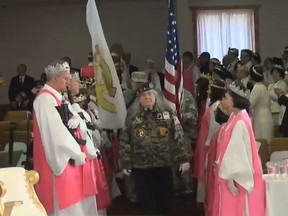 In this screenshot, the World Peace and Unification Sanctuary in Newfoundland, Penn. holds a ceremony including AR-15 rifles.