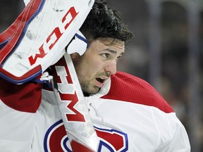 Montreal Canadiens goalie Carey Price takes off his mask and waits for the trainer Tuesday, Feb. 20, 2018 in Philadelphia. (AP Photo/Tom Mihalek)