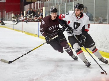 Carleton's Mike Constantine looks to the middle of the ice with Mathieu Newcomb in pursuit.