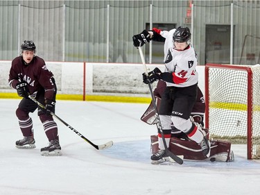 Carleton's Adam Chapman works in tight against uOttawa goalie Anthony Brodeur while Brendan Jacome looks on.