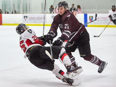 The Ravens' Alexandre Boivin goes down after a collision with uOttawa's Michael Poirier during an Ontario University Athletics playoff game at the Carleton University Ice House on Wednesday, Feb. 14, 2018.