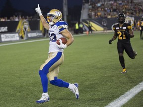 Julian Feoli-Gudino, left, crosses the goal line for a touchdown in the Bombers' game against the Tiger-Cats on Aug. 12.