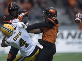 Loucheiz Purifoy, right, dislodges the ball from the grip of Adarius Bowman with a hit during a Lions-Eskimos game at Vancouver on Oct. 22, 2016.