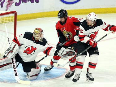 New Jersey Devils goaltender Keith Kinkaid (1) makes a glove save as Ottawa Senators Colin White (36) and Devils Sami Vatanen (45) look on during first period NHL action in Ottawa, Tuesday, February 6, 2018 .