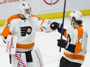 Philadelphia Flyers goaltender Petr Mrazek (left) and centre Sean Couturier celebrate after defeating the Ottawa Senators 5-3 in NHL action, Saturday February 24, 2018 in Ottawa.