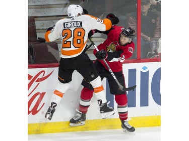 Ottawa Senators defenceman Fredrik Claesson collides with Philadelphia Flyers centre Claude Giroux along the boards during third period NHL action, Saturday, February 24, 2018 in Ottawa. The Flyers defeated the Senators 5-3.