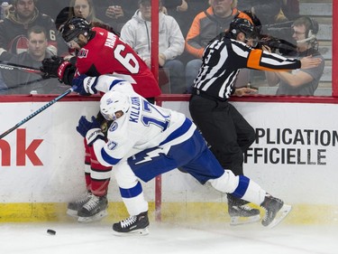 Referee Chris Rooney tries to avoid a collision with Lightning winger Alex Killorn and Senators defenceman Ben Harpur along the boards during the first period of Thursday's game at Canadian Tire Centre.