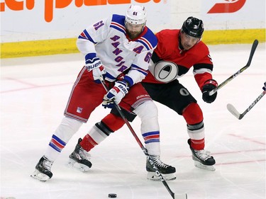 Ottawa Senators defenceman Cody Ceci and the New York Rangers' Rick Nash battle for the puck.