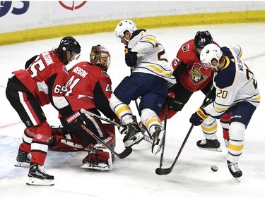The Buffalo Sabres' Jason Pominville gets tangled up with the Ottawa Senators' Matt Duchene as the Sabres' Scott Wilson (20) tries to get a shot against Erik Karlsson and goaltender Craig Anderson.