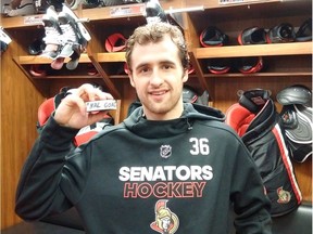 Colin White shows off the puck with which he scored his first NHL goal against the Devils on Tuesday night. Bruce Garrioch/Postmedia