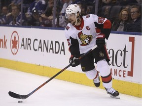 Captain Erik Karlsson stickhandles behind the Senators net.