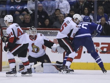 Toronto's James van Riemsdyk, right, fights off a check by Ottawa's Cody Ceci and tips the puck past netminder Mike Condon for the Leafs' fourth goal. Jack Boland/Postmedia