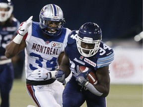 #34 Jerious Norwood about to be tackled by Kyries Hebert in 1st half action as the Toronto Argonauts played the Montreal Alouettes tonight at the Rogers Centre during CFL action in Toronto, Ont. on Friday November 1, 2013.