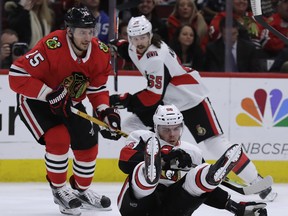 Senators winger Magnus Paajarvi (right) hits the ice as he battles against Blackhawks centre Artem Anisimov on Wednesday night in Chicago. (The Associated Press)