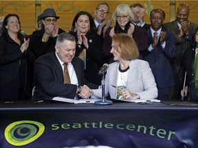 Seattle Mayor Jenny Durkan, right, shakes hands with Oak View Group CEO Tim Leiweke after they signed an agreement to renovate KeyArena in Seattle on Dec. 6.