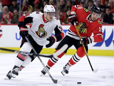 Ottawa Senators defenceman Mark Borowiecki skates the puck up ice against Chicago Blackhawks centre Artem Anisimov.