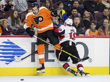 The Flyers' Brandon Manning, left, reacts to colliding into the boards with Senators winger Tom Pyatt during the third period.