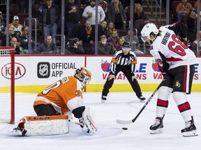Ottawa Senators' Mike Hoffman, right, shoots the puck past Philadelphia Flyers' Michal Neuvirth, left, for the game-winning goal during a shootout in an NHL hockey game, Saturday, Feb. 3, 2018, in Philadelphia. The Senators won 4-3 in a shootout.