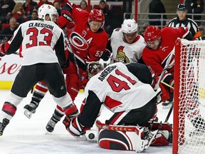 Senators goalie Craig Anderson (41) reaches for a loose puck in his crease during Tuesday's game against the Hurricanes.