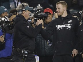 Philadelphia Eagles coach Doug Pederson, left, and and injured quarterback Carson Wentz, right, celebrate near the end of the Eagles' 38-7 win over the Minnesota Vikings during the NFC championship NFL football game Sunday, Jan. 21, 2018, in Philadelphia.