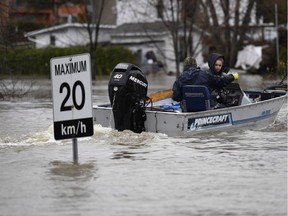 People in a motor boat arriving to help deliver sandbags pass a sign intended for cars.