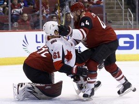 Arizona Coyotes defenceman Kevin Connauton sends Ottawa Senators winger Mark Stone to the ice during Saturday night's game. (AP PHOTO)