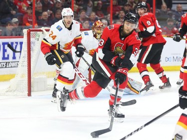 Fredrik Claesson of the Senators tries to control the puck against the Flames during first-period action. Jean Levac/Postmedia