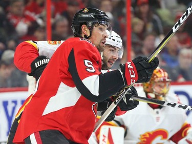 Cody Ceci of the Senators and Mark Giordano of the Flames fight for position in the first period of Friday's game. Jean Levac/Postmedia