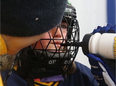 With tears streaming down her cheeks after taking a stick in the gut, Metcalfe Hornet Maggie Rose gets checked out by head coach Karla George on the bench. Minutes later she was back in the game.  Julie Oliver/Postmedia