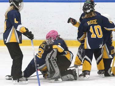 Metcalfe Hornets goalie Sarah Miller (pink helmet) gets swarmed by teammates after their victory against Gloucester-Cumberland. The Printwheel NCRRL ringette championship weekend kicked off in rinks across the region.  Julie Oliver/Postmedia