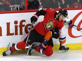 Ottawa Senators' Magnus Paajarvi hits New York Islanders centre Mathew Barzal during Tuesday night's game. (THE CANADIAN PRESS)