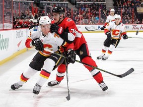 Seantors defenceman Mark Borowiecki leans on the Flames' Micheal Ferland in a battle for position along the boards during the first period of Friday's game. The Flames won the contest 2-1.