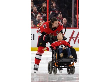 Senators captain Erik Karlsson escorts Campbell Labonté to centre ice for a ceremonial puck before Friday's game.