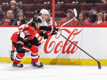 Erik Karlsson of the  Senators defends against Matthew Tkachuk of the Flames in the first period.
