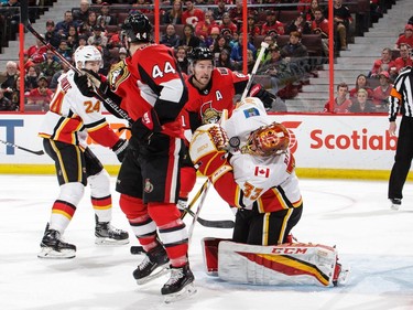 A shot by the Senators bounces off the mask of Flames netminder in the second period.