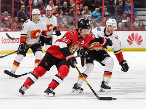 Mark Stone of the Senators protects the puck from Matt Stajan of the Flames in the third period of Friday's game at Canadian Tire Centre. Stone was hurt when Calgary's Micheal Ferland tumbled into his leg from behind.