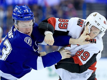 Adam Erne #73 of the Tampa Bay Lightning and Max McCormick #89 of the Ottawa Senators fight during a game  at Amalie Arena on March 13, 2018 in Tampa, Florida.