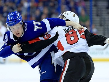 Adam Erne #73 of the Tampa Bay Lightning and Max McCormick #89 of the Ottawa Senators fight during a game  at Amalie Arena on March 13, 2018 in Tampa, Florida.